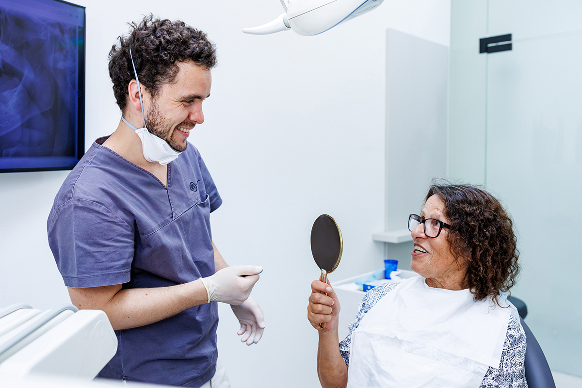 Dr. Artúr Varajti, Zahnarzt und Oralchirurg bei Artdent Zahnklinik, lächelt mit seinem zufriedenen Patienten nach der Klickprothese-Behandlung.