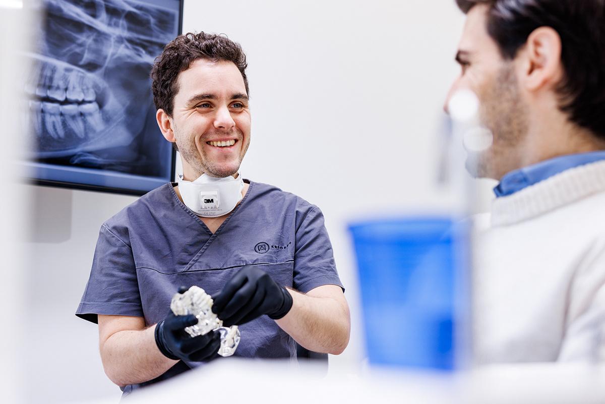 artdent-all-on-4-kosten-ober-und-unterkiefer-1 Zahnarzt der Artdent Zahnklinik erklärt einem Patienten am Kiefermodell und an der Panorama-Röntgenaufnahme die All-on-4-Behandlung