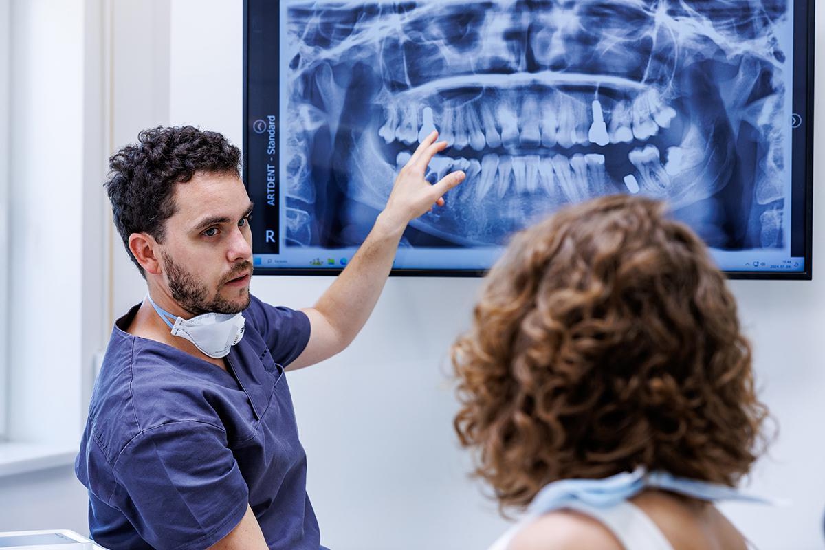 artdent-was-kostet-ein-zahnimplantat-in-ungarn-1 Dr. Artur Varajti erklärt einem Patienten die Kosten eines Zahnimplantats beim kostenlosen Informationsgespräch in Tirol.